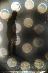 欧美悬疑剧海报，昏暗光线下侦探站在犯罪现场，氛围紧张神秘
